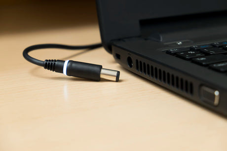 Close-up of laptop with cable on table