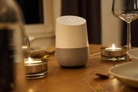 Close-up of google home and candles on table