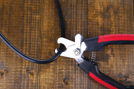 Side cutters cut cable on wooden background