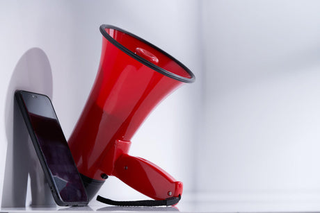 Smart phone and megaphone on white background