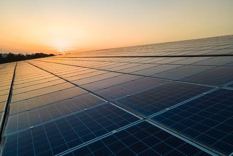 solar panels mounted on building roof for producing clean ecological electricity at sunset