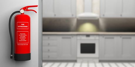 Fire extinguisher on wall blur house kitchen background 