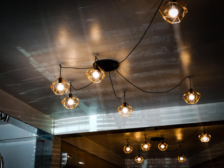Low angle view of illuminated pendant lights hanging from ceiling