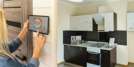 Woman using smartphone monitor to control home connectivity interface