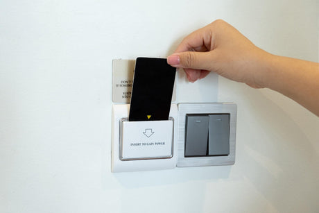Closeup women hand insert key card to opening light electronic in hotel room