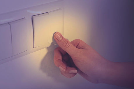 Woman turning off light switch indoors closeup 