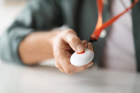 senior man pushing panic button on emergency equipment