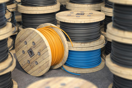 Wire electric cable on wooden coil or spool isolated on warehouse