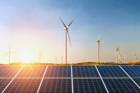 Solar panels and wind turbine with sunset on the hill.