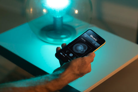 hand holding a mobile device controlling lighting wirelessly 